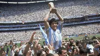 Penyerang Argentina, Diego Maradona, mengangkat trofi Piala Dunia saat usai mengalahkan Jerman Barat pada laga final Piala Dunia 1986 di Meksiko, (29/6/1986). (Photo by - / AFP)