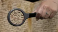 Ahli Manuskrip memperlihatkan detail tulisan pada penggalan naskah Al-Quran tertua di dunia berusia setidaknya 1.370 tahun, di Universitas Birmingham, Inggris, Rabu (22/7/2015). (REUTERS/Peter Nicholls)