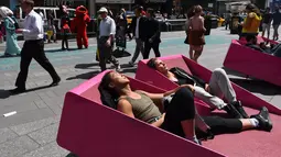 Sejumlah orang menerima tantangan untuk berjemur di sebuah tempat yang telah disediakan di Times Square, New York, AS, Selasa (2/5). (AFP PHOTO / TIMOTHY A. CLARY)
