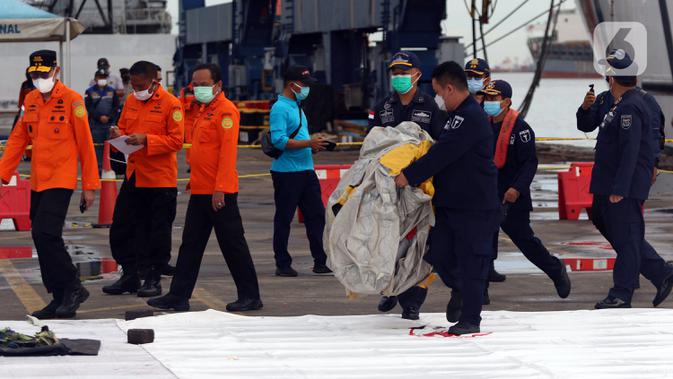 Petugas KPLP dan Basarnas memeriksa barang temuan yang diduga serpihan pesawat Sriwijaya Air SJ 182 di Dermaga JICT 2, Jakarta, Minggu (10/1/2021). Sriwijaya Air SJ 182 hilang kontak empat menit usai lepas landas dari Bandara Soetta. (Liputan6.com/Helmi Fithriansyah)
