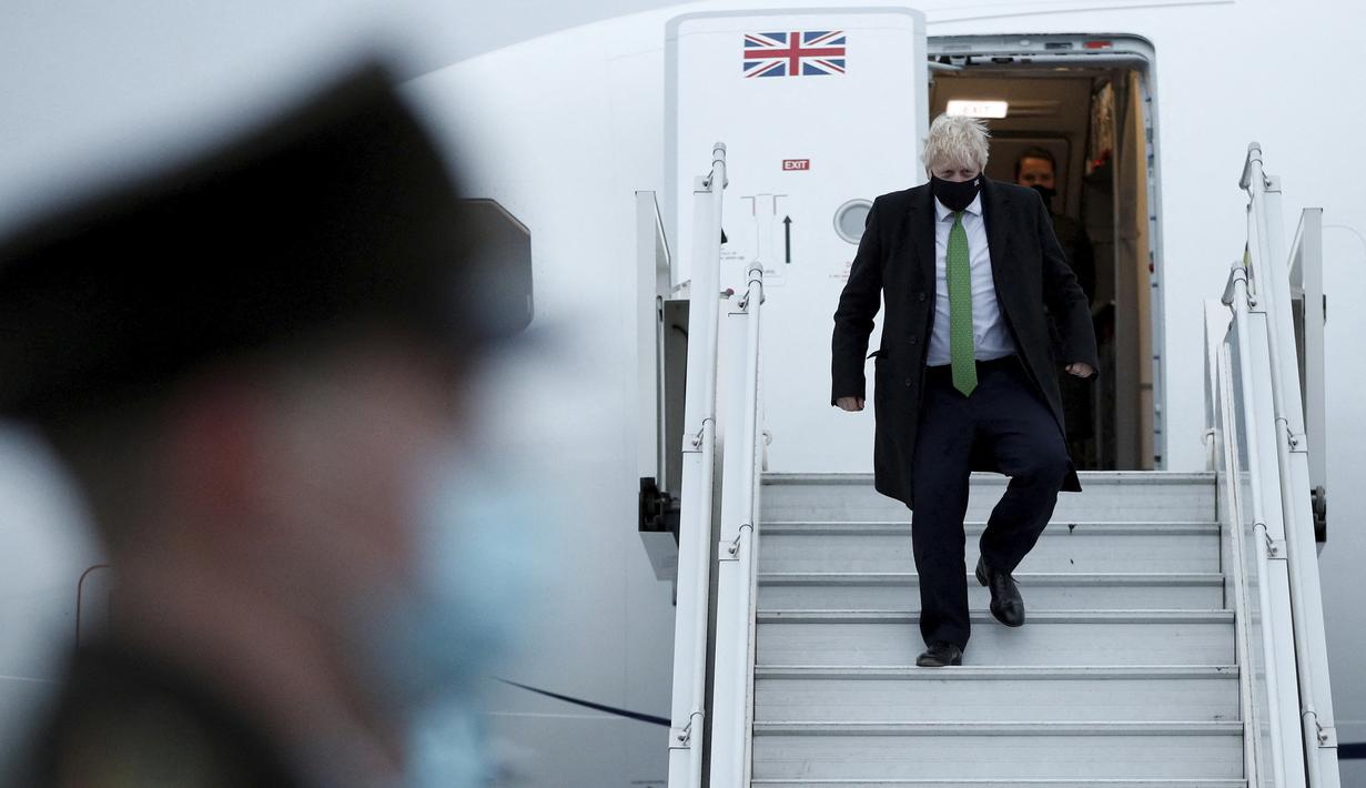 Perdana Menteri Inggris Boris Johnson turun dari pesawat saat ia tiba di Kyiv, Ukraina, Selasa (1/2/2022).  Johnson dijadwalkan bertemu dengan Presiden Ukraina Volodymyr Zelenskyy di tengah meningkatnya ketegangan dengan Rusia. (Peter Nicholls/Pool Photo via AP)