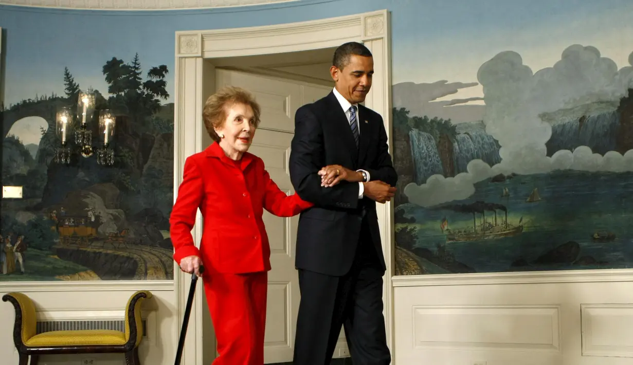 Presiden AS Barack Obama, mengawal mantan ibu negara, Nancy Reagan pada sebuah acara di Gedung Putih, 2 Juni 2009. Nancy yang meninggal dunia pada usia 94 tahun dianggap sebagai salah satu sosok ibu negara paling berpengaruh. (REUTERS/Kevin Lamarque)