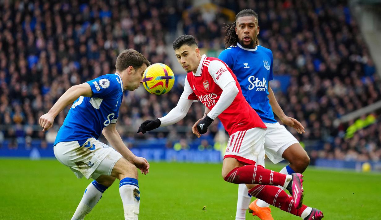 Pemain Arsenal Gabriel Martinelli (tengah) berebut bola dengan pemain Everton Seamus Coleman (kiri) dan Alex Iwobi pada pertandingan sepak bola Liga Inggris di Goodison Park, Liverpool, Inggris, 4 Februari 2023. Everton mengalahkan Arsenal dengan skor 1-0. (AP Photo/Jon Super)
