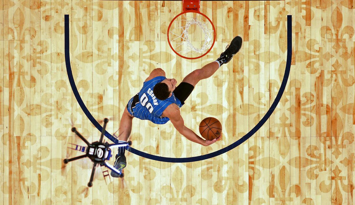 Pemain Orlando Magic,  Aaron Gordon mencoba melakukan slam dunk  saat drone terbang di atasnya pada kontes slam dunk NBA All-Star Saturday Night di New Orleans, (18/2/2017). (AP/Gerald Herbert, Pool)