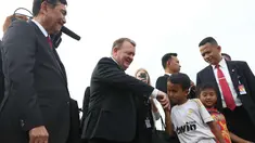 Seorang anak bersalaman dengan PM Denmark Lars Lokke Rasmussen didampingi Menko Kemaritiman, Luhut Pandjaitan di bantaran sungai belakang Museum Bahari, Jakarta, (28/11). Kedatangannya guna mendukung agenda kelautan Indonesia. (Liputan6.com/Angga Yuniar)