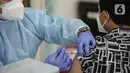 Petugas kesehatan menyuntikkan vaksin covid-19 kepada seorang pria di Aula Masjid Cut Meutia, Jakarta, Sabtu (14/8/2021). Pemprov DKI berkolaborasi dengan Dewan Masjid Indonesia menggelar vaksinasi yang ditujukan untuk 400 orang jemaah dan warga sekitar masjid. (Liputan6.com/Faizal Fanani)
