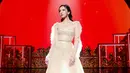 Dengan latar panggung berwarna merah, Lyodra tampil luar biasa cantik mengenakan dress bernuansa netral yang penuh payet dengan detail ruffles di bagian lengan dan ujung gaun. Foto: Instagram.