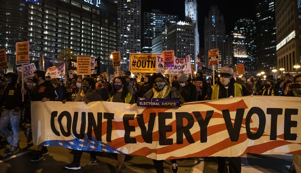Para pengunjuk rasa berbaris melewati Loop untuk menuntut penghentian penghitungan suara dalam pemilihan umum di Chicago, Amerika Serikat, Rabu (4/11/2020). (Ashlee Rezin Garcia/Chicago Sun-Times via AP)