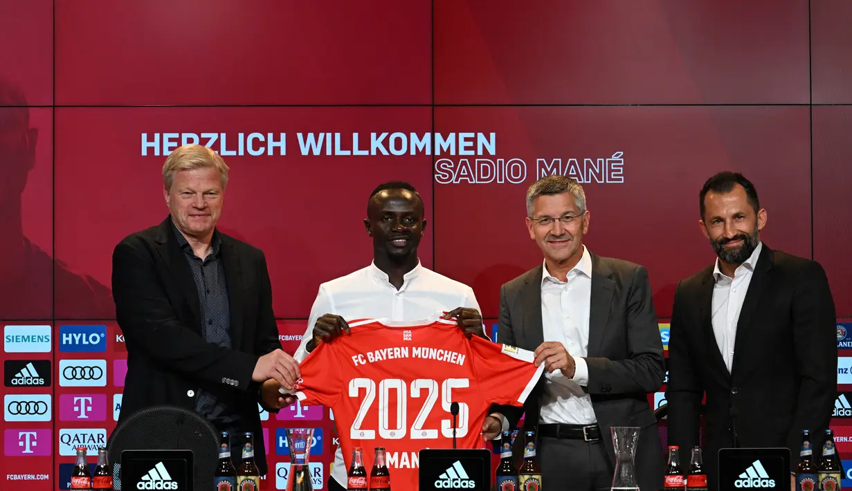 Penyerang baru Bayern Munchen, Sadio Mane (kedua kiri) dengan jerseynya berpose di samping CEO Bayern Munchen Oliver Kahn (kiri), Presiden Herbert Hainer (kedua) dan Direktur Olahraga Hasan Salihamidzic selama konferensi pers setelah ia menandatangani kontrak tiga tahun di Munich, Jerman selatan (22/6/2022). (AFP/CHRISTOF STACHE)