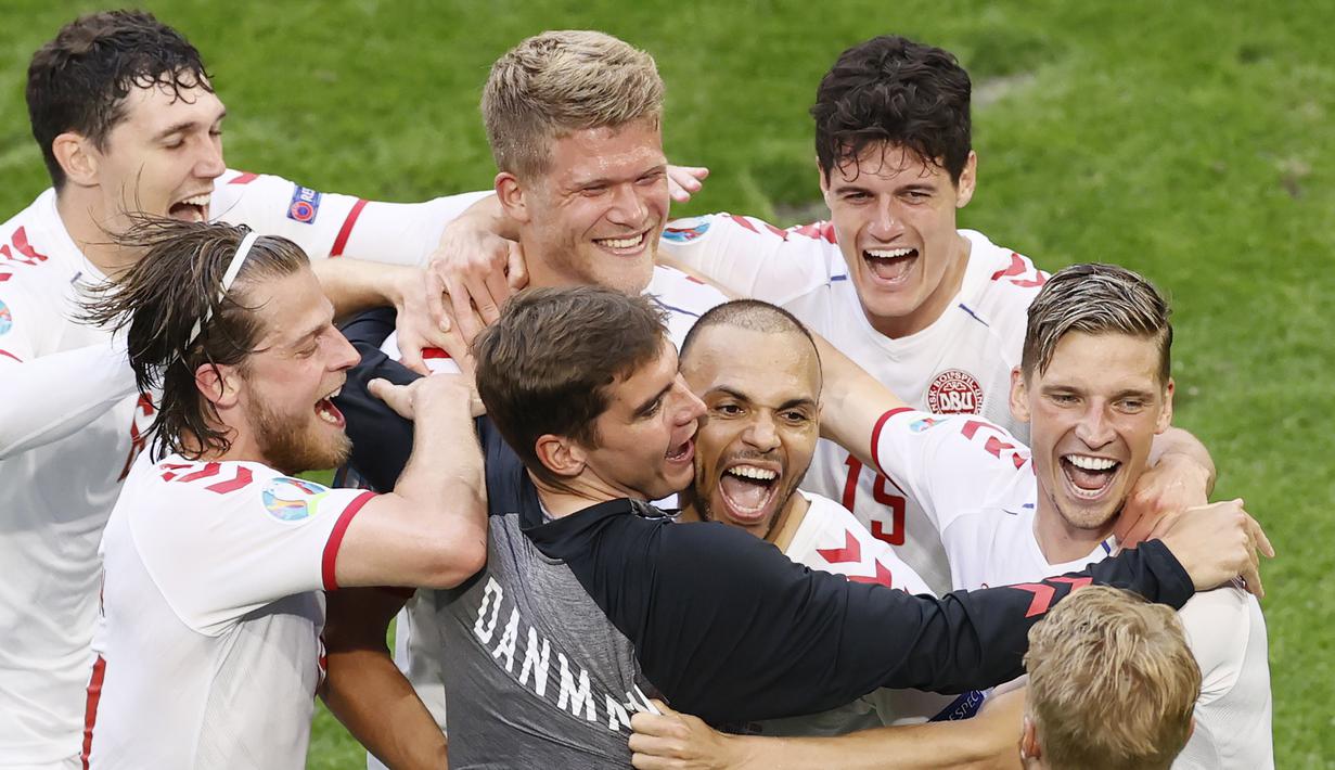 Para pemain Timnas Denmark ramai-ramai memeluk Martin Braithwaite usai ia mencetak gol ke gawang Wales pada babak 16 besar Euro 2020 di Johan Cruyff Arena, Sabtu (26/7/2021). (Koen van Weel, Pool via AP)
