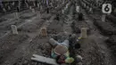 Petugas beristirahat di antara makam dengan protokol covid-19 di TPU Rorotan, Jakarta, Rabu (14/7/2021). Data untuk pasien meninggal per 14 Juli 2021 sebanyak 991 orang sehingga total akumulatif saat ini ada 69.210 orang yang meninggal dunia akibat corona di Indonesia. (Liputan6.com/Johan Tallo)