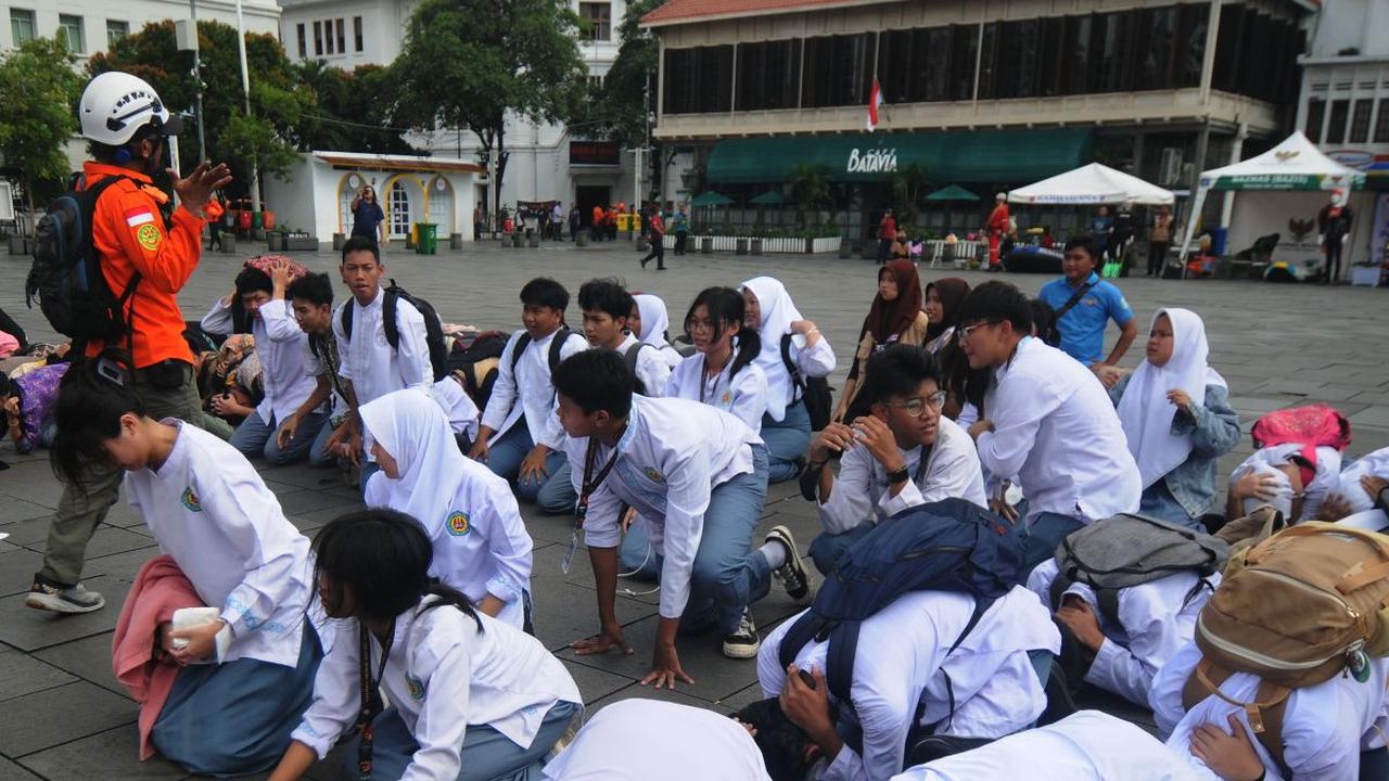 Sejumlah siswa merunduk ketika sirine gempa meraung-raung dalam simulasi yang digelar pada Hari Kesiapsiagaan Bencana 2024 di kawasan Kota Tua, Jakarta, Jumat (26/4/2024).&nbsp;Relawan yang tergabung dalam Tim Penanggulangan Bencana Indonesia menggelar pe