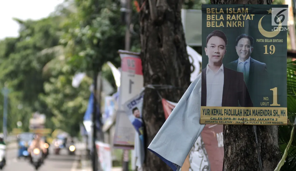 Alat peraga kampanye (APK) calon anggota legislatif (caleg) menghiasi pepohonan yang berada di pinggir jalan, Jakarta, Rabu (20/3). Pemasangan APK tersebut melanggar aturan PKPU Nomor 23 Pasal 31 Tentang Bahan Kampanye. (merdeka.com/Iqbal Nugroho)