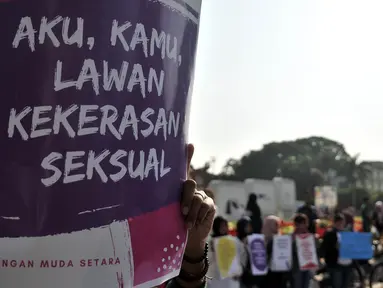 Massa yang tergabung dalam Jaringan Muda Setara menunjukkan poster saat aksi menuntut keadilan untuk WA korban pemerkosaan di kawasan Bundaran HI, Jakarta, Minggu (5/8). (Merdeka.com/Iqbal S. Nugroho)