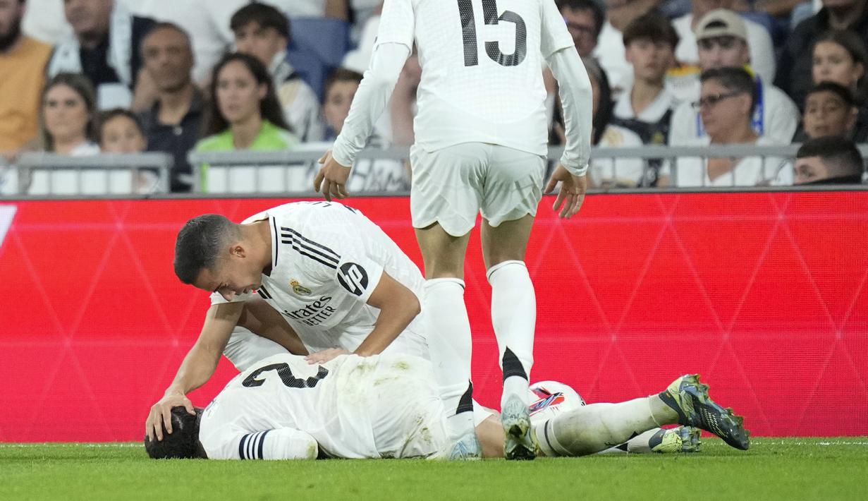 Carvajal mengerang sambil memegang lututnya saat tengkurap di lapangan. Rekan setimnya berusaha menenangkannya sambil meminta pertolongan medis. (AP Photo/Bernat Arnangue)
