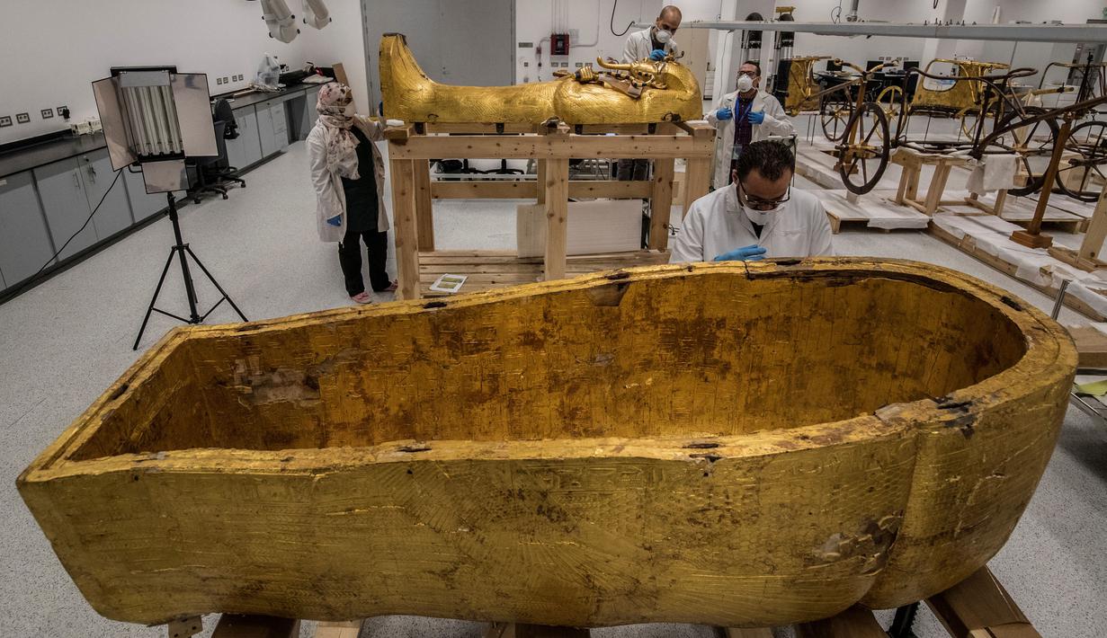 Para arkeolog merestorasi sarkofagus atau peti mati emas Firaun Tutankhamun di laboratorium restorasi Grand Egyptian Museum (GEM), Giza, Mesir, Senin (13/4/2020). Firaun Tutankhamun merupakan Raja Mesir Kuno yang memerintah antara tahun 1342-1325 SM. (Khaled DESOUKI AFP)