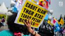 Seorang pengunjuk rasa menunjukkan poster saat menggelar aksi di depan Istana Negara, Jakarta, Senin (25/9). Aksi tersebut sebagai peringatan Hari Tani Nasional (HTN) 2017. (Liputan6.com/Faizal Fanani)