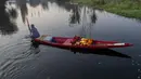 Seorang pedagang bunga Kashmir mendayung kapalnya melalui Danau Dal di Srinagar, Kashmir yang dikuasai India (18/10/2020). (AP Photo/Dar Yasin)