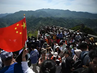 Orang-orang memanjat Tembok Besar China di Badaling, utara Beijing, hari pertama dari 5 hari libur nasional Hari Buruh atau May Day, Rabu (1/5/2024). (GREG BAKER / AFP)