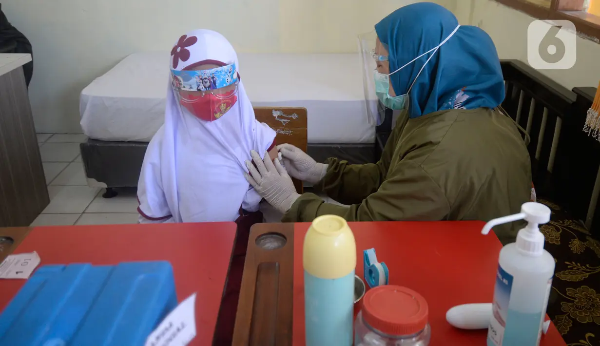 Petugas Puskesmas melakukan imunisasi campak kepada siswa kelas I saat pelaksanaan Bulan Imunisasi Anak Sekolah (BIAS) di SDN Serua 3, Ciputat, Tangsel, Selasa (1/9/2020). Kegiatan itu untuk memberikan kekebalan terhadap siswa dari penyakit campak, difteri dan tetanus. (merdeka.com/Dwi Narwoko)