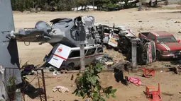 Sebuah helikopter milter Meksiko jatuh menimpa mobil van di Santiago Jamiltepec, negara bagian Oaxaca, Sabtu (17/2). Helikopter nahas itu jatuh di atas dua mobil van di sebuah lapangan terbuka ketika berupaya mendarat. (AP/Luis Alberto Cruz Hernandez)