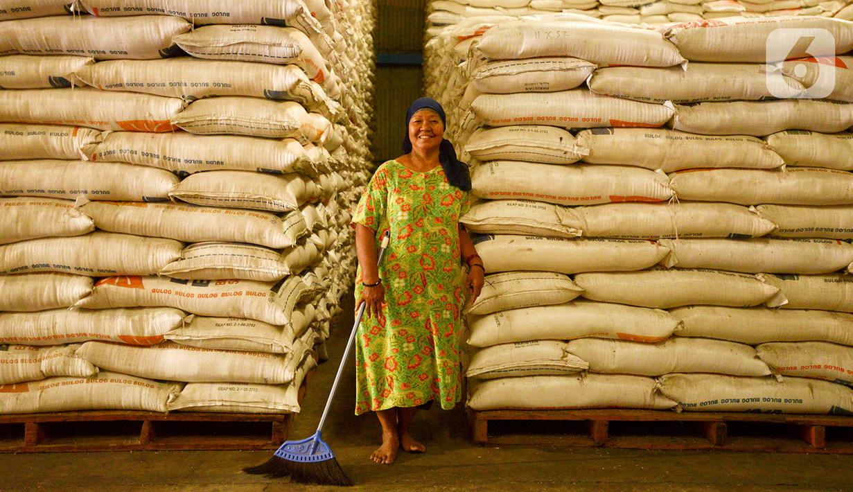 Pekerja tersenyum di samping karung beras Bulog di Kelapa Gading, Jakarta, Kamis (27/2/2020). Jelang Ramadan dan Idul Fitri 2020 Perusahaan Umum Badan Urusan Logistik atau Perum Bulog siap mengamankan pasokan beras di seluruh wilayah Indonesia mencapai 1,7 juta ton. (merdeka.com/Imam Buhori)