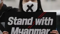 Seorang anggota kelompok pemuda membawa poster selama unjuk rasa di dekat kedutaan Myanmar di Seoul, Korea Selatan, Jumat (5/2/2021). Militer Myanmar melakukan kudeta dan Senin 1 Februari dan menahan sejumlah tokoh termasuk Aung San Suu Kyi. (AP Photo/Lee Jin-man)