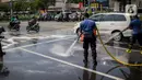 Sejumlah personil pemadam kebakaran membersihkan tumpah oli yang terjadi di Jalan Veteran depan Gedung Krida Bakti, Jakarta, Kamis (16/1/2020). Petugas damkar  melakukan pembersihan dengan cairan deterjen maupun campuran khusus agar jalan tersebut tidak lagi licin. (Liputan6.com/Faizal Fanani)
