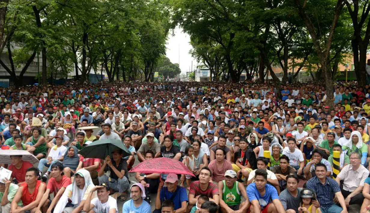 Ribuan warga Filipina berkumpul di sebuah taman umum untuk menyaksikan petinju kebanggaan mereka, Manny Pacquiao, bertarung melawan Timothy Bradley, Minggu (13/4/2014). (AFP PHOTO/Jay Directo)