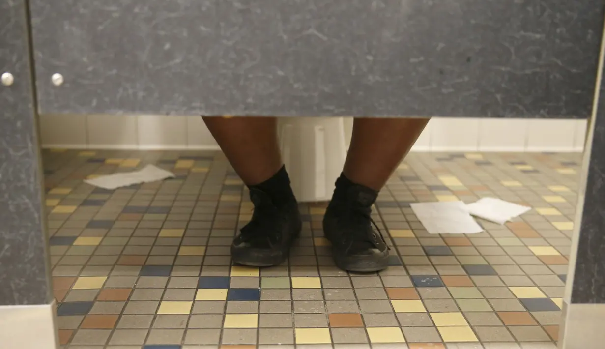 Siswa duduk di dalam toilet netral gender pertama di distrik sekolah Los Angeles di Santee High School, Los Angeles, California, AS, Senin (18/4). Toilet disediakan sebagai langkah mendukung dan menampung siswa transgender. (REUTERS/Lucy Nicholson)