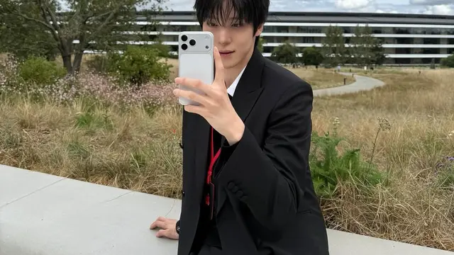 Pesona Yunho ATEEZ tampil memegang iPhone 17 silver.  [@yunou._.u]