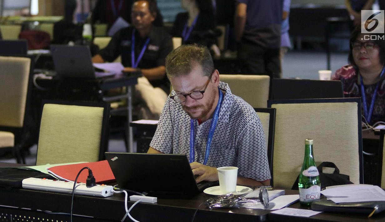 Seorang jurnalis mengetik berita pertemuan tahunan IMF-Bank Dunia di Nusa Dua, Bali, Senin (8/10). Menkominfo Rudiantara memastikan fasilitas internet kencang untuk tamu dan media dalam pertemuan tahunan ini. Liputan6.com/Angga Yuniar)