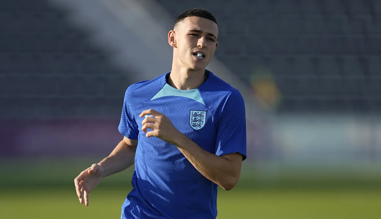 Gelandang Inggris, Phil Foden melakukan pemanasan saat mengikuti sesi latihan di Kompleks Olahraga Al Wakrah di Al Wakarah, Qatar, Senin, 28 November 2022.  Inggris akan bertanding melawan Wales pada lanjutan grup B Piala Dunia 2022. (AP Photo/Abbie Parr)