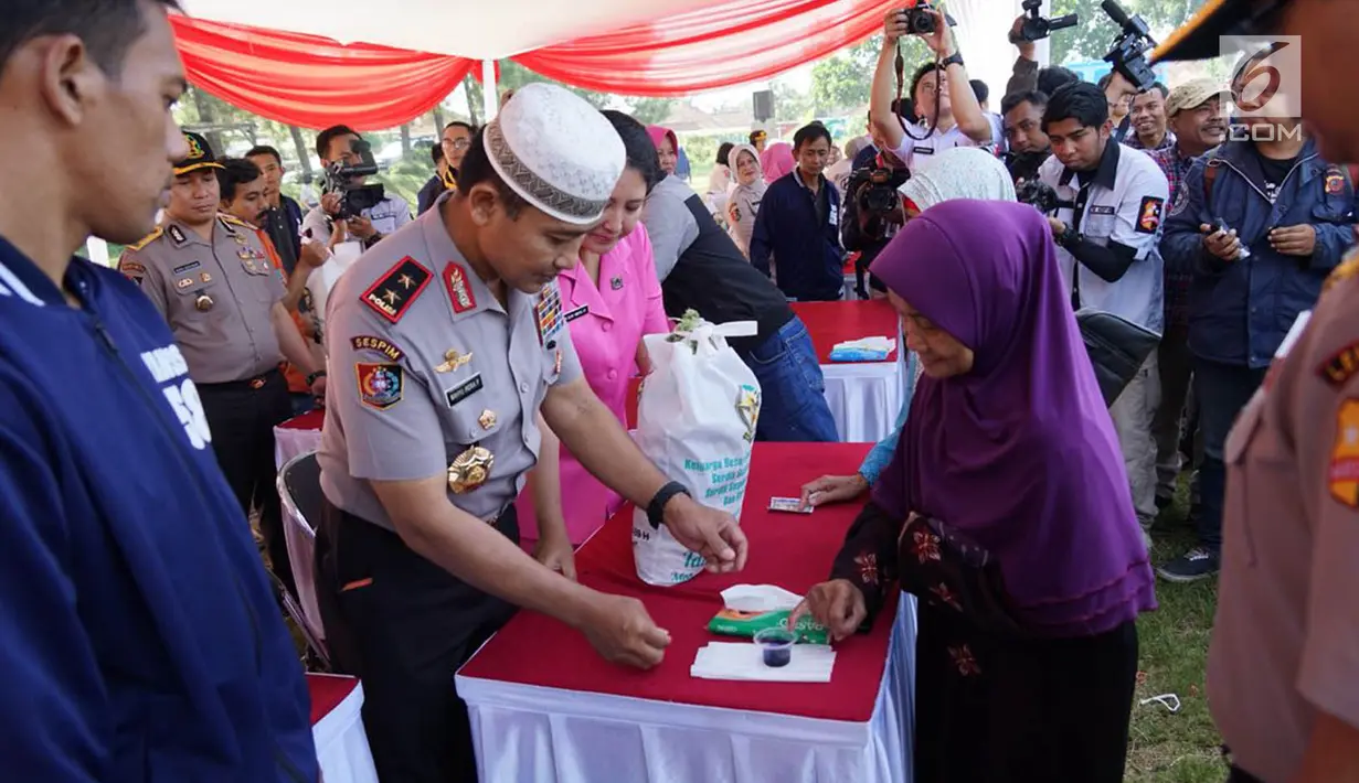 Kasespim Irjen Pol Wahyu Indra Pramugari melayani warga saat bazar murah di Asrama Unit Barat, Jawa Barat, Senin (04/6). Sekolah Staf dan Pemimpin Tinggi Polri (Sespimti) menggelar bakti sosial, bazar murah dan paket lebaran. (Liputan6.com/Pool/Sespimti)