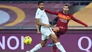 Gelandang AS Roma, Henrikh Mkhitaryan, berebut bola dengan bek Torino, Bremer, pada laga lanjutan Liga Italia di Stadion Olimpico, Jumat (18/12/2020) dini hari WIB. AS Roma menang 3-1 atas Torino. (AFP/Vincenzo Pinto)