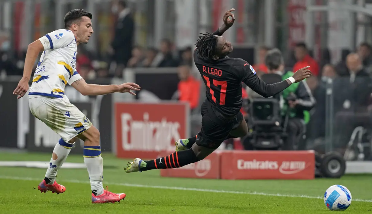 Bek Verona, Nicolo Casale (kiri) berebut bola dengan penyerang AC Milan, Rafael Leao pada pekan kedelapan Liga Italia 2021/2022 di San Siro, Minggu (17/10/2021) dini hari WIB. AC Milan menang dramatis atas Hellas Verona 3-2. (AP Photo/Antonio Calanni)