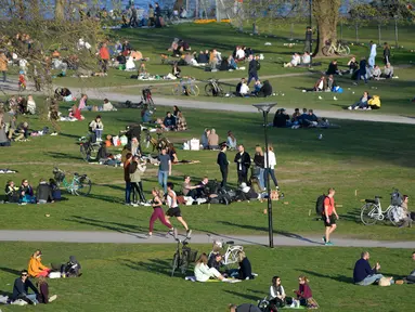 Orang-orang menikmati cuaca hangat di Stockholm, Rabu (22/4/2020). Swedia belum memberlakukan lockdown, seperti mayoritas negara Eropa lainnya, namum pemerintah memberikan tanggung jawab besar kepada penduduknya untuk membantu mengurangi penyebaran virus corona. (Anders WIKLUND/TT NEWS AGENCY/AFP)