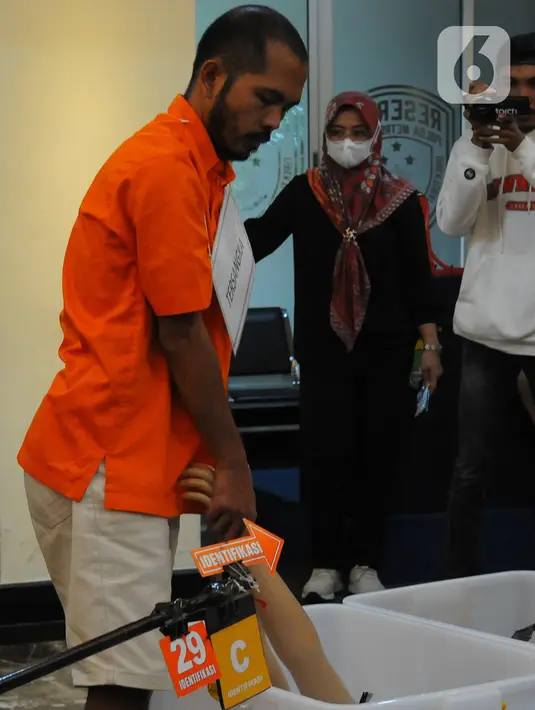 Tersangka Mel alias Ecky (43) melakukan salah satu adegan dalam rekonstruksi pembunuhan dan mutilasi Angela Hindriati (54) di Direktorat Reserse Kriminal Umum Polda Metro Jaya, Jakarta, Rabu  (1/3/2023). Ecky menjalani 60 adegan rekonstruksi dalam rangkaian peristiwa pembunuhan dan mutilasi untuk pengambilalihan kepemilikan Apartemen Taman Rasuna milik Angela Hindriati. (merdeka.com/Imam Buhori)