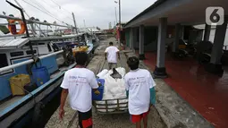 Jurnalis membawa gerobak berisi bantuan sembako di Pulau Panjang, Serang, Banten, Sabtu (30/1/2021). Kegiatan Jurnalis Peduli yang bekerjasama dengan BNI dan Jamkrindo bertujuan meringankan beban warga terdampak Covid-19 yang memiliki mata pencarian sebagai nelayan. (Liputan6.com/Pool/JP)