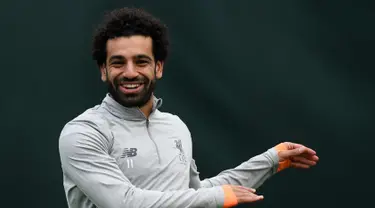 Penyerang Liverpool asal Mesir Mohamed Salah tersenyum saat melakukan pemanasan di kompleks pelatihan Melwood tim di Liverpool, Inggris barat laut, (23/4). Liverpool akan bertanding melawan wakil Italia, AS Roma di stadion Anfield. (AFP Photo/Paul Ellis)