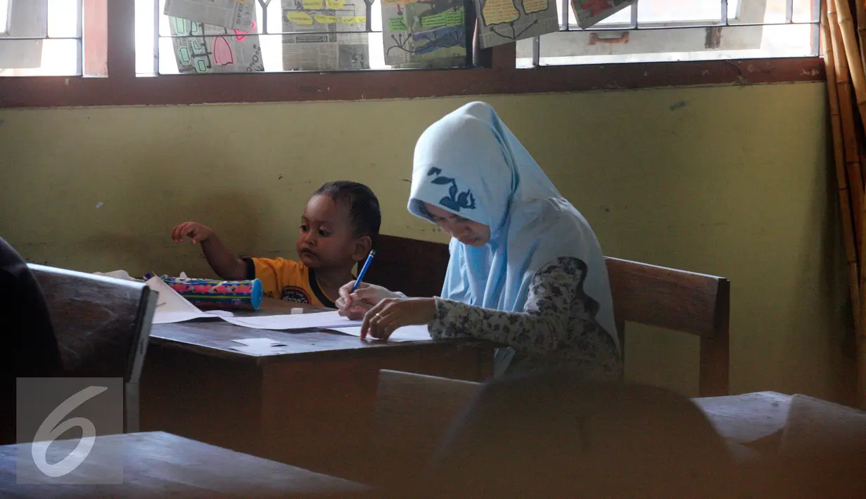 Seorang peserta membawa anaknya saat mengikuti ujian kesetaraan Paket C di SMPN 15 Yogyakarta, Senin (4/4). Sebanyak 447 peserta mengikuti ujian akhir untuk mendapatkan ijazah setingkat SMA. (Liputan6.com/Boy Harjanto)