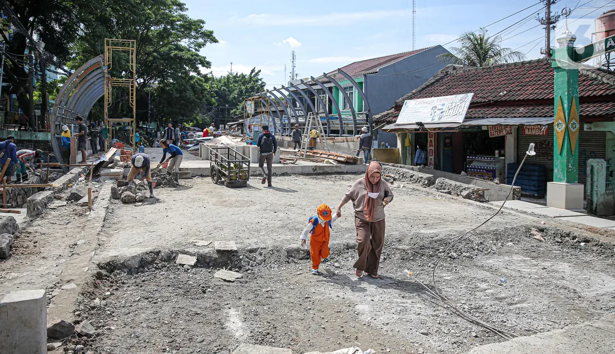 Warga melintas di dekat pembangunan revitalisasi Jembatan Cibubur, Jakarta, Senin (24/10/2022). Jembatan Cibubur yang saat ini sedang direvitalisasi, akan dilengkapi akses untuk pejalan kaki. Jembatan Cibubur yang menghubungkan Pasar Rebo dan Ciracas itu akan ditinggikan guna menghindari genangan ketika permukaan Kali Cipinang meninggi dan ditargetkan selesai pada bulan November 2022. (Liputan6.com/Faizal Fanani)