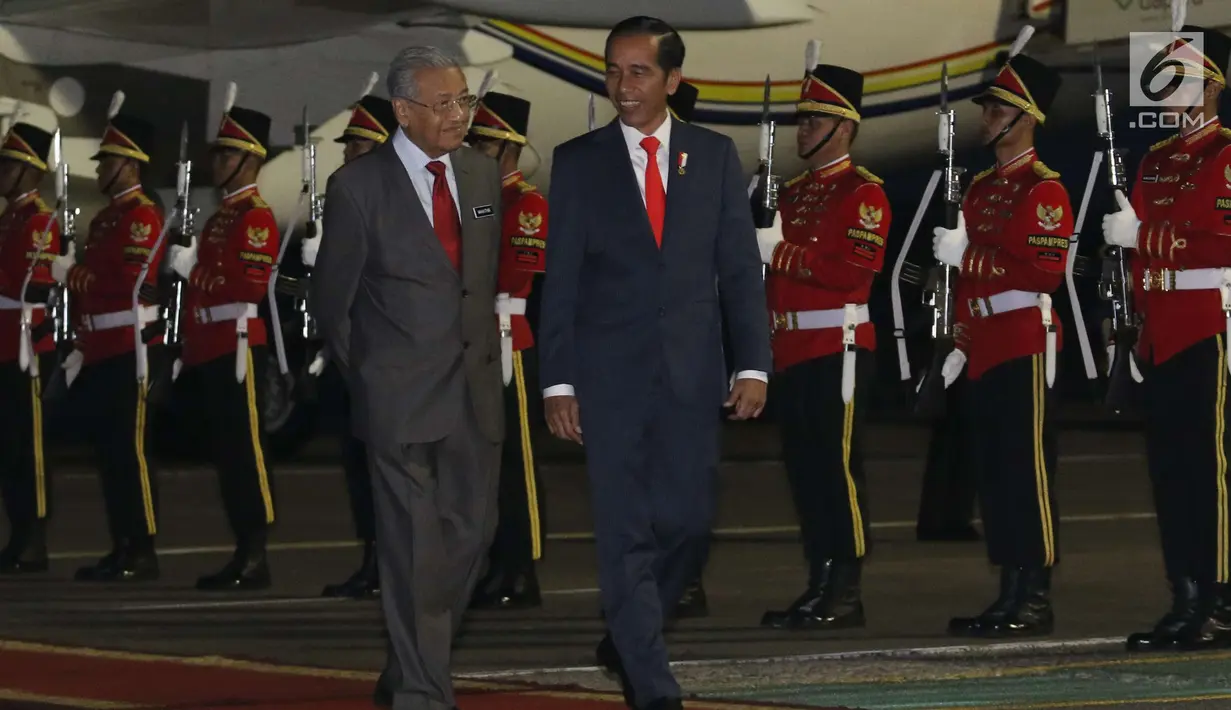 Presiden Joko Widodo menyambut PM Malaysia Mahathir Mohamad di Bandara Halim Perdanakusuma, Jakarta, Kamis (28/6). Dalam kunjungannya ke Jakarta,  Mahathir ditemani sang istri, Siti Hasmah Mohd Ali. (Liputan6.com/Angga Yuniar)