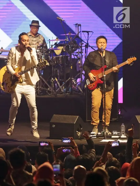 Aksi panggung Jikustik bersama mantan vokalisnya, Pongki Barata (kiri) dalam konser bertajuk 'Jikustik Reunian' di Grand Pasific Hall, Yogyakarta, Jumat (29/3). Ribuan penonton tak malu mengeluarkan suara mereka dan bernyanyi bersama. (Fimela.com/Bambang E. Ros)