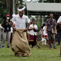 Anak-anak bersemangat mengikuti lomba balap karung usai mengikuti upacara peringatan detik-detik Proklamasi di halaman Tugu Pahlawan Banjar Penglipuran, Kabupaten Bangli, Bali, Kamis (17/8/2023). (Liputan6.com/Helmi Fithriansyah)