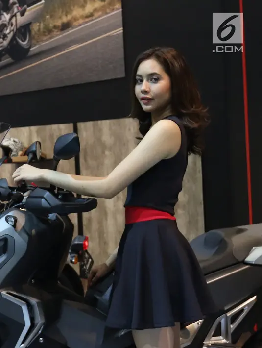 SPG bepose di samping sepeda motor Honda selama pameran Pameran Indonesia Motorcycle Show (IMOS) 2018 di JCC, Jakarta, Kamis (1/10). IMOS 2018  berlangsung pada 31 Oktober-4 November 2018. (Liputan6.com/Angga Yuniar)