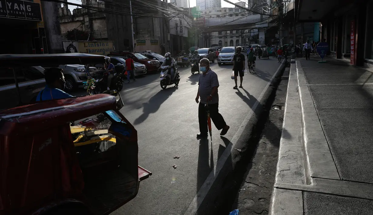 Orang-orang mengenakan masker berjalan-jalan di pusat kota Manila, setelah pelonggaran pembatasan karantina wilayah (lockdown), di Filipina, Rabu (2/9/2020). Pemerintah melonggarkan lockdown meskipun negara tersebut memiliki infeksi virus corona terbanyak di Asia Tenggara. (AP Photo/Aaron Favila)