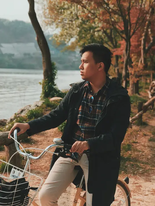 Saat liburan di Korea Selatan, Joshua terlihat kece dengan pose yang sedang naik sepeda. Ia kini tampil dengan kemeja yang dipadukan dengan jaket parka dan celana panjang. (Liputan6.com/IG/@jojosuherman)
