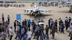 Perwira militer asing dan pengunjung berjalan melewati jet tempur J-10C dari Angkatan Udara Tentara Pembebasan Rakyat China (PLA) yang dipamerkan selama Airshow China 2021 di Zhuhai di provinsi Guangdong, China (38/9/2021). (AP Photo/Ng Han Guan)