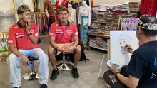 Rider Moto2 Mario Suryo Aji dan rider Moto3 Veda Ega Pratama saat dilukis di salah satu toko souvenir di kawasan Bali Collection, Nusa Dua pada Sabtu (18/7/2026). (Bola.com/Alit Binawan)